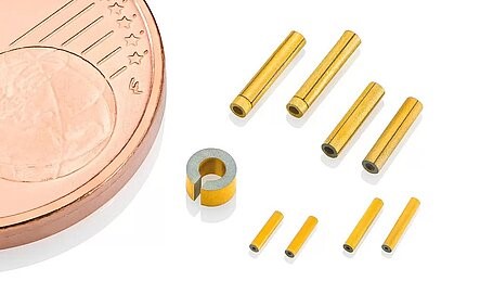 Miniature PZT piezo scanner tubes next to a euro coin for scale
