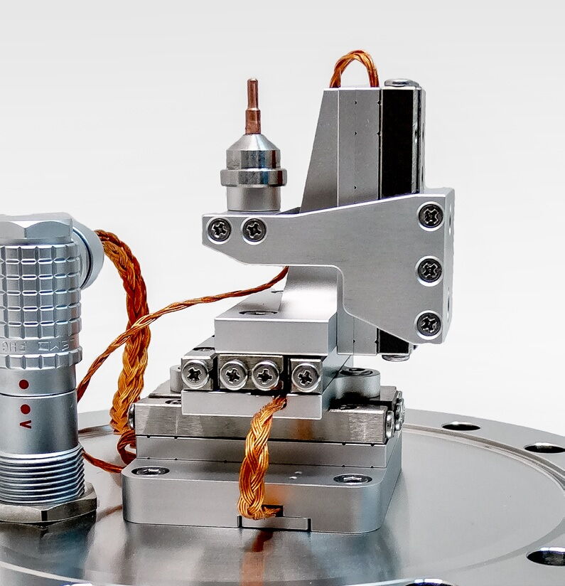 SmarAct UHV対応圧電ステージ。真空フランジ上に搭載、全セラミック・金属構造で超高真空動作に対応